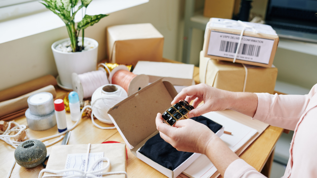 woman shipping handmade jewelry on desk with packages ready to ship