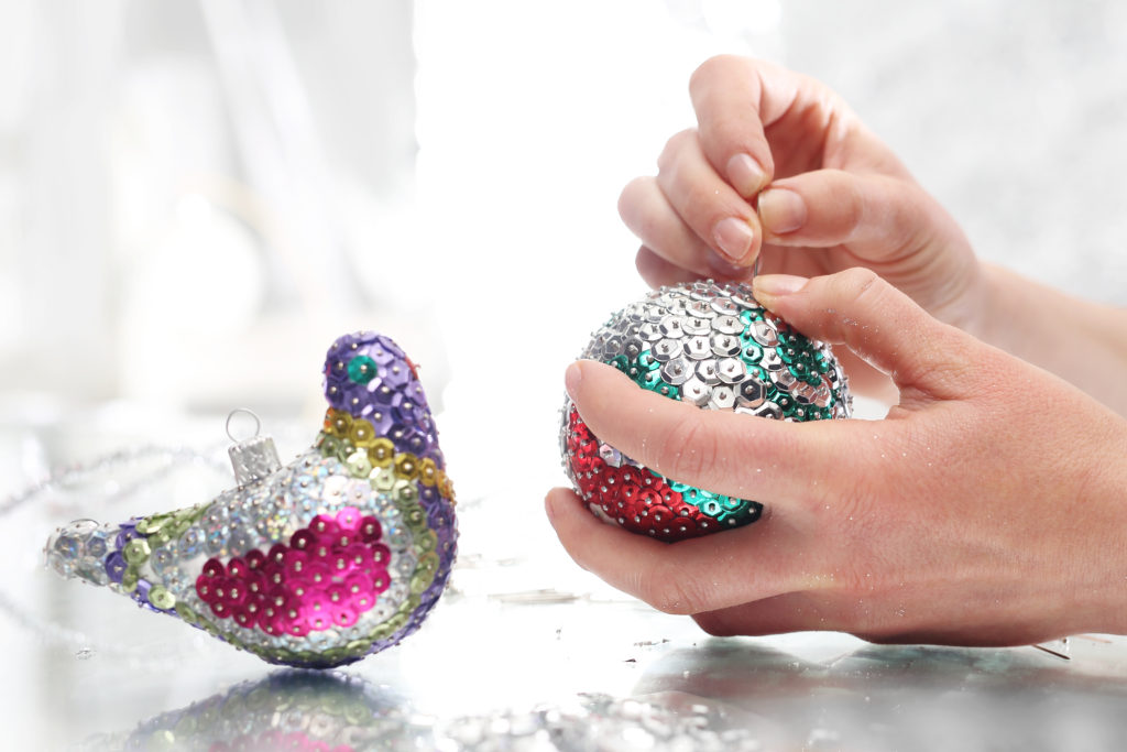 hands working on handmade sequined christmas ornaments