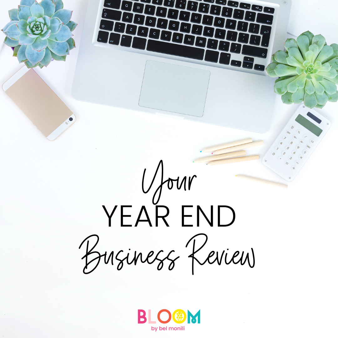 Your Year End Business Review title on white desktop with laptop and succulent plants